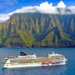 NCL Pride of America cruising past the green cliffs of the Napali Coast on Kauai