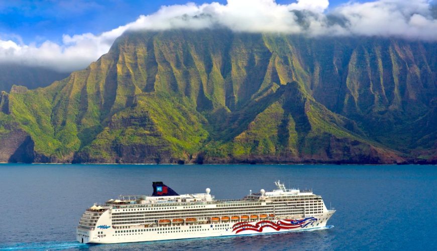 NCL Pride of America cruising past the green cliffs of the Napali Coast on Kauai
