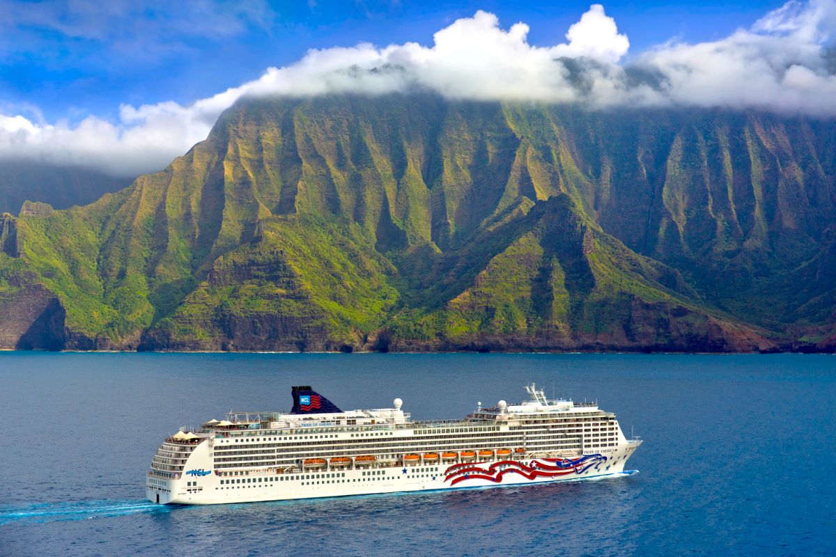 NCL Pride of America cruising past the green cliffs of the Napali Coast on Kauai