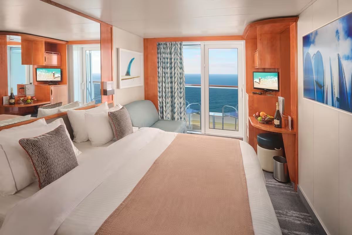The same balcony cabin made up as one bed, with the balcony and ocean beyond