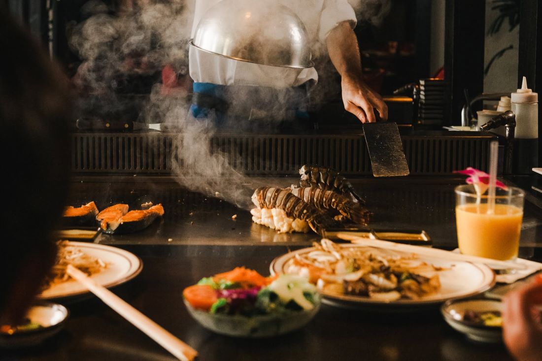 Lobster tails and vegetables cooking on the teppan griddle