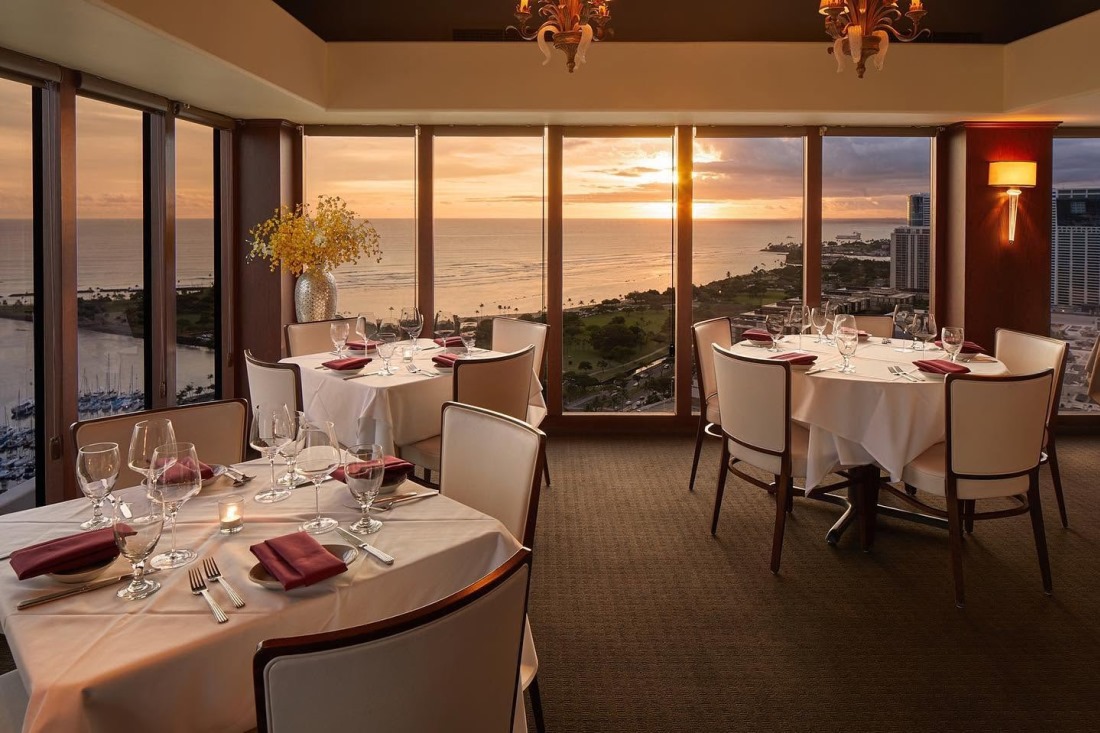 Window tables at The Signature on the 36th floor, with the sunset over the Honolulu coastline